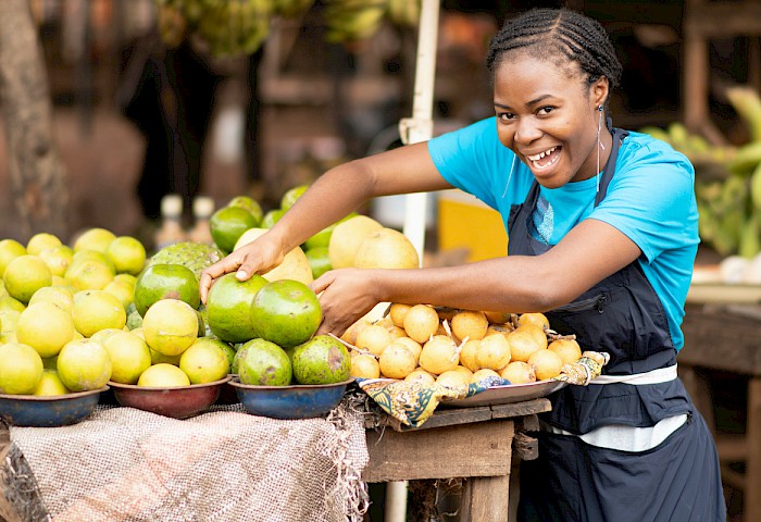 a lady selling fruits at the market